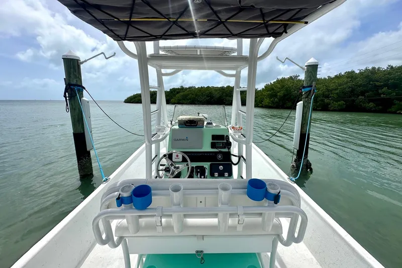 Slide: The Image of 2023 Blazer Bay 2400 boat docked on calm water, featuring a modern console and equipment. - 27