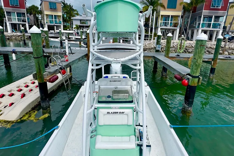 Slide: The Image of 2023 Blazer Bay 2400 boat docked at a marina with colorful waterfront houses. - 29