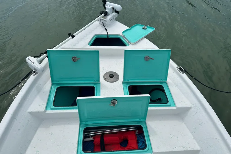 Slide: The Image of Open storage compartments on a 2023 Blazer Bay 2400 boat, featuring turquoise lids. - 3