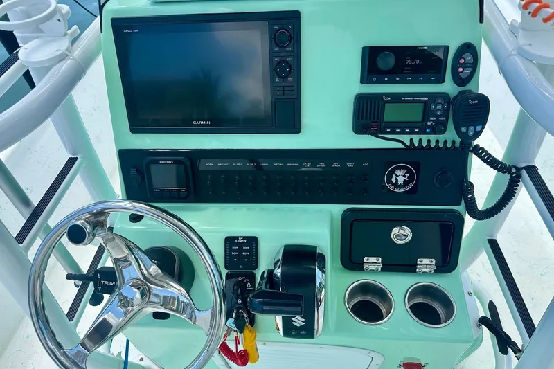 Slide: The Image of 2023 Blazer Bay 2400 boat dashboard with steering wheel, Garmin display, and control panel. - 30
