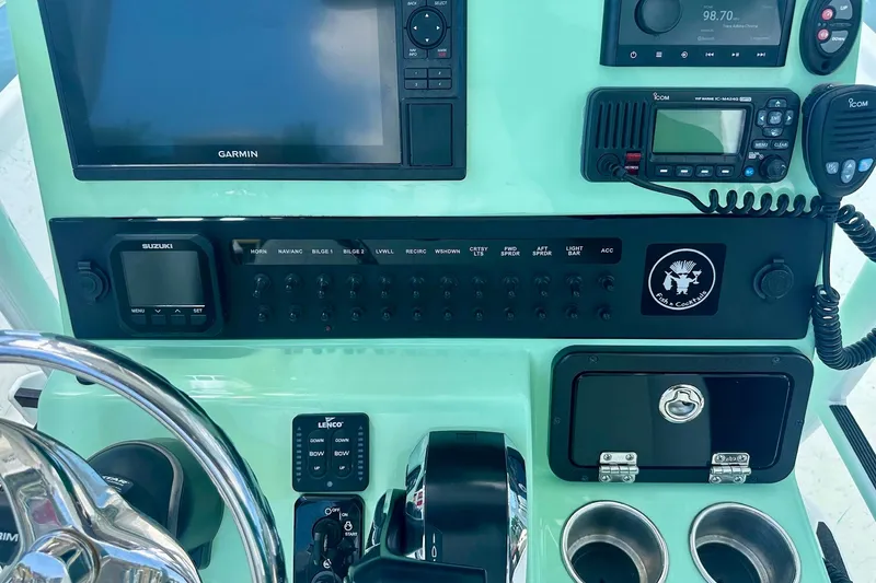 Slide: The Image of 2023 Blazer Bay 2400 boat dashboard with Garmin and Suzuki controls. - 33