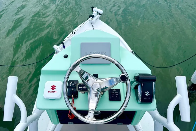 Slide: The Image of Steering console of 2023 Blazer Bay 2400 boat with Suzuki controls on calm water. - 39