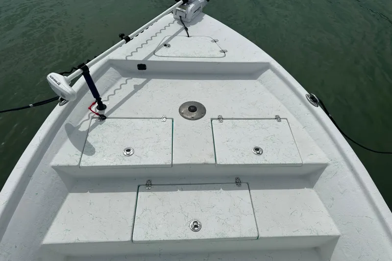 Slide: The Image of 2023 Blazer Bay 2400 boat deck with storage compartments and trolling motor. - 4