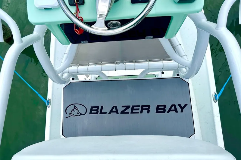 Slide: The Image of 2023 Blazer Bay 2400 boat helm with logo and steering wheel. - 40