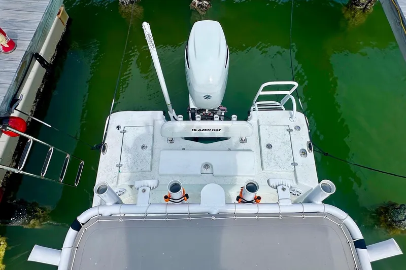 Slide: The Image of 2023 Blazer Bay 2400 boat docked in green water, viewed from above. - 42