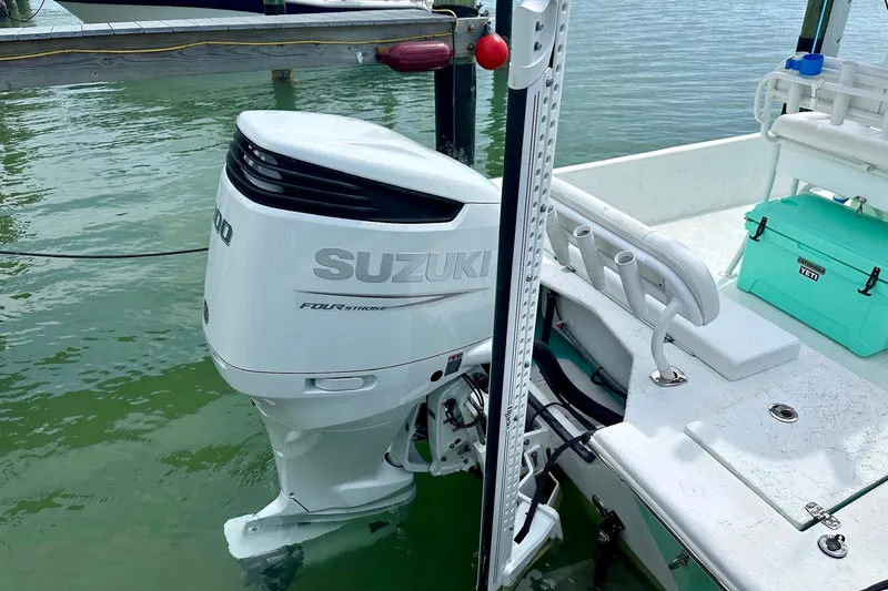 Slide: The Image of A 2023 Blazer Bay 2400 boat with Suzuki outboard motor docked by the water. - 43