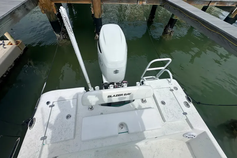 Slide: The Image of 2023 Blazer Bay 2400 boat docked, featuring a Suzuki outboard motor and Power-Pole anchor. - 6