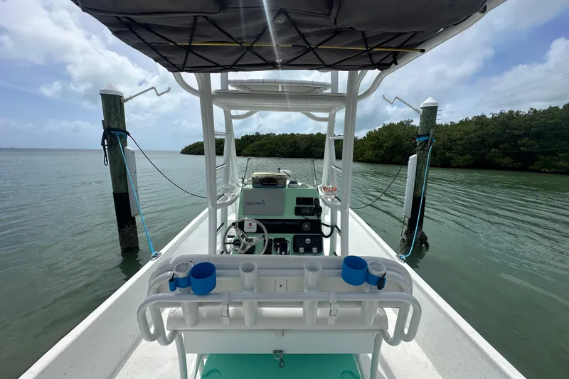 Slide: The Image of 2023 Blazer Bay 2400 boat docked on calm water with lush greenery. - 7