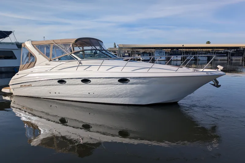 The Image of 2001 Wellcraft 3300 Martinique boat docked on calm water under clear skies. - 0
