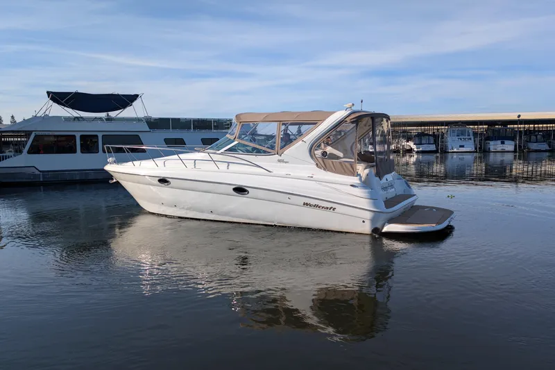 Slide: The Image of 2001 Wellcraft 3300 Martinique boat docked in a marina, calm water reflections. - 10