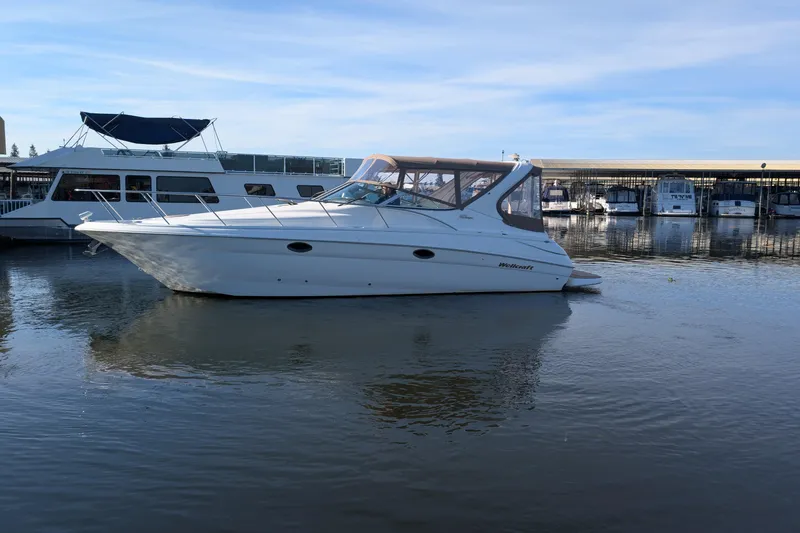 Slide: The Image of 2001 Wellcraft 3300 Martinique boat docked in a marina under clear skies. - 11