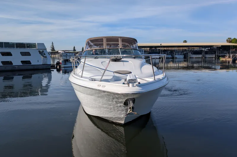 Slide: The Image of 2001 Wellcraft 3300 Martinique boat docked in a marina, calm water reflections. - 2