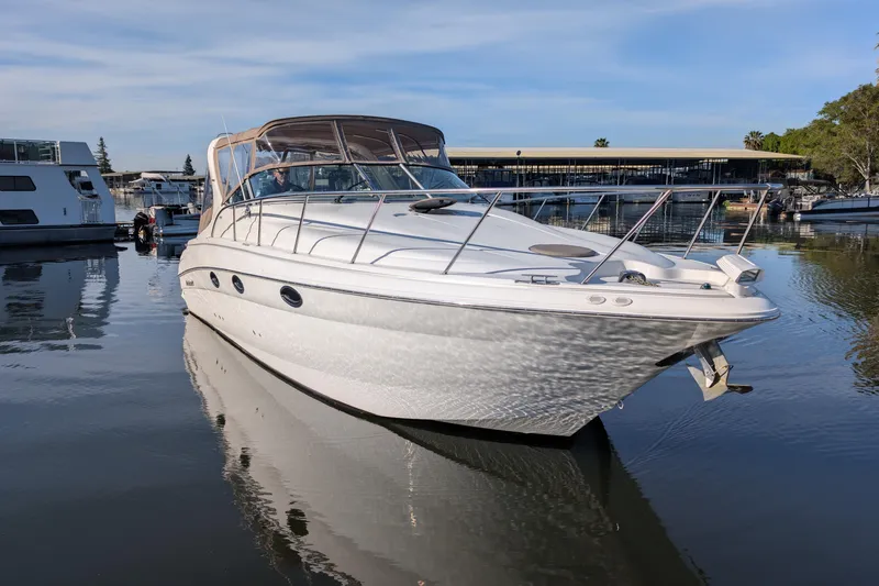Slide: The Image of 2001 Wellcraft 3300 Martinique boat docked in a marina, reflecting on calm water. - 3