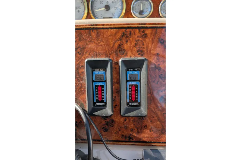 Slide: The Image of 2001 Wellcraft 3300 Martinique dashboard with trim tab controls and gauges. - 34