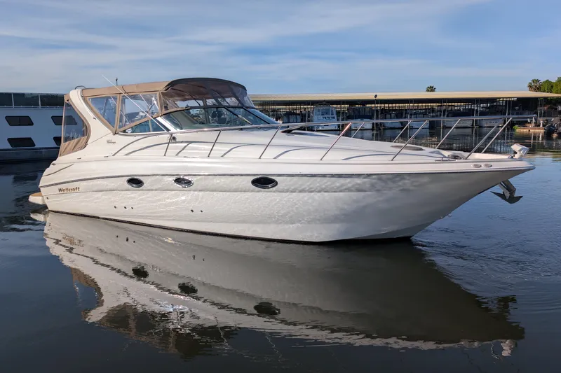 Slide: The Image of 2001 Wellcraft 3300 Martinique boat docked on calm water, showcasing sleek design. - 4