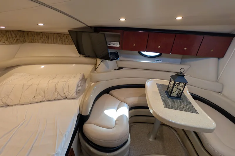 Slide: The Image of 2001 Wellcraft 3300 Martinique cabin interior with cozy seating, table, and ambient lighting. - 42