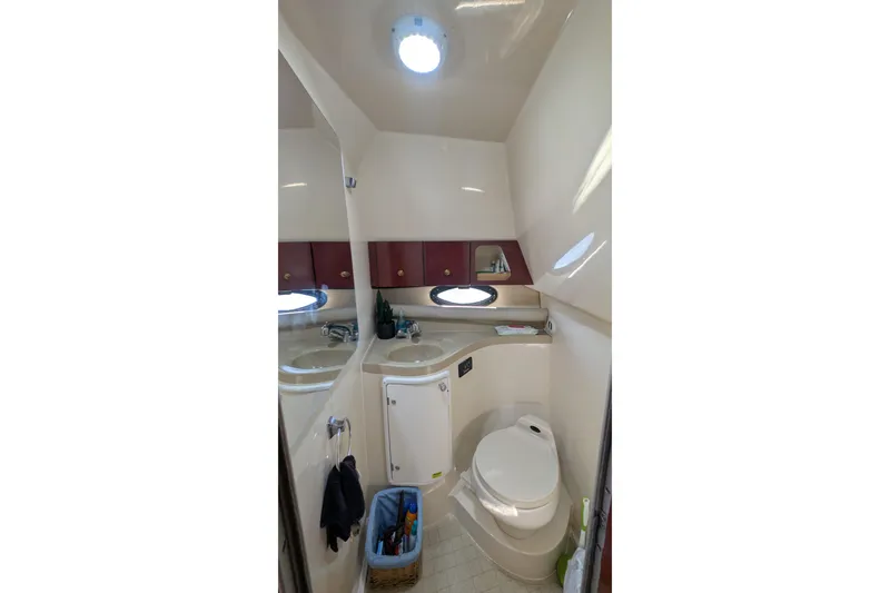 Slide: The Image of 2001 Wellcraft 3300 Martinique boat bathroom with sink, toilet, and storage cabinets. - 55