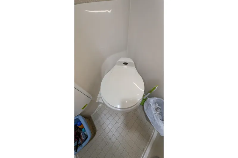 Slide: The Image of 2001 Wellcraft 3300 Martinique boat bathroom with toilet and cleaning supplies. - 56