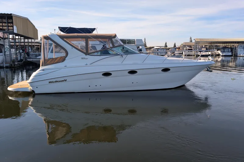 Slide: The Image of 2001 Wellcraft 3300 Martinique boat docked at marina, calm water reflection. - 6