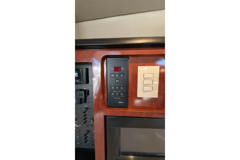 Slide: The Image of Control panel of a 2001 Wellcraft 3300 Martinique boat, featuring digital display and switches. - 62
