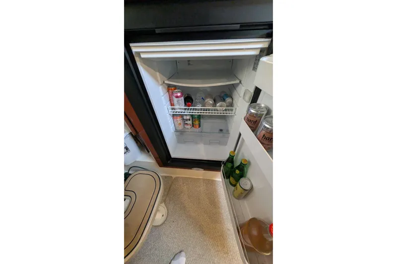 Slide: The Image of Mini fridge stocked with beverages inside a 2001 Wellcraft 3300 Martinique boat. - 65
