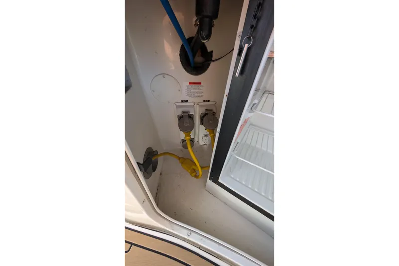 Slide: The Image of Electrical connections inside a 2001 Wellcraft 3300 Martinique boat, featuring a yellow power cord. - 67