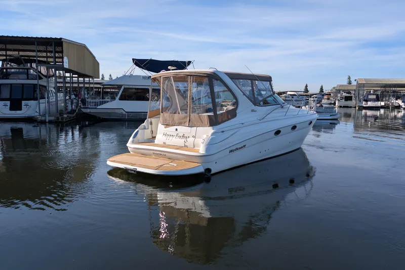 Slide: The Image of 2001 Wellcraft 3300 Martinique boat docked in a marina, calm water reflections. - 7