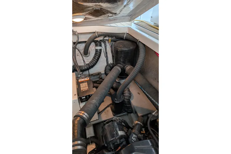 Slide: The Image of Engine compartment of a 2001 Wellcraft 3300 Martinique boat, showing hoses and components. - 74