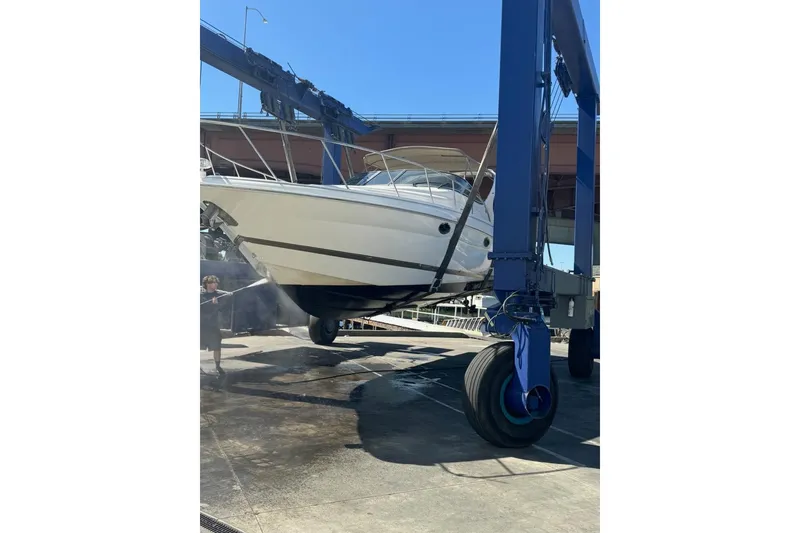 Slide: The Image of 2001 Wellcraft 3300 Martinique boat being lifted by a crane for maintenance. - 79