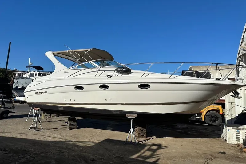 Slide: The Image of 2001 Wellcraft 3300 Martinique boat on dry dock under clear blue sky. - 80