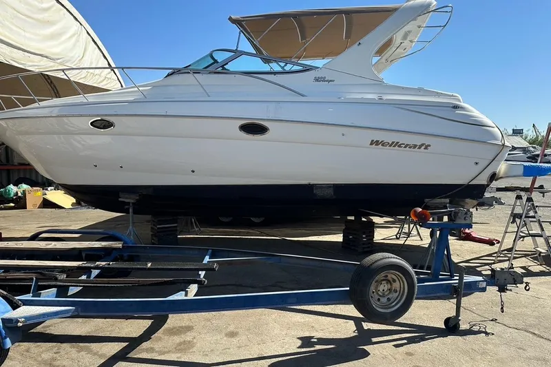 Slide: The Image of 2001 Wellcraft 3300 Martinique boat on trailer, parked outdoors under clear sky. - 81