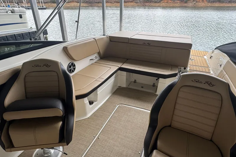 Slide: The Image of 2020 Sea Ray SPX 230 boat interior with beige seating and water view. - 7