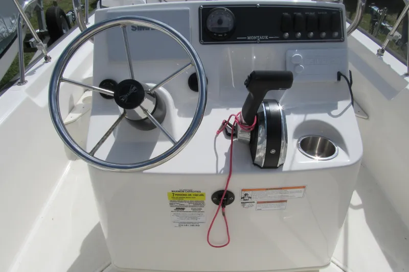 Slide: The Image of 2023 Boston Whaler 170 Montauk boat console with steering wheel and controls. - 11