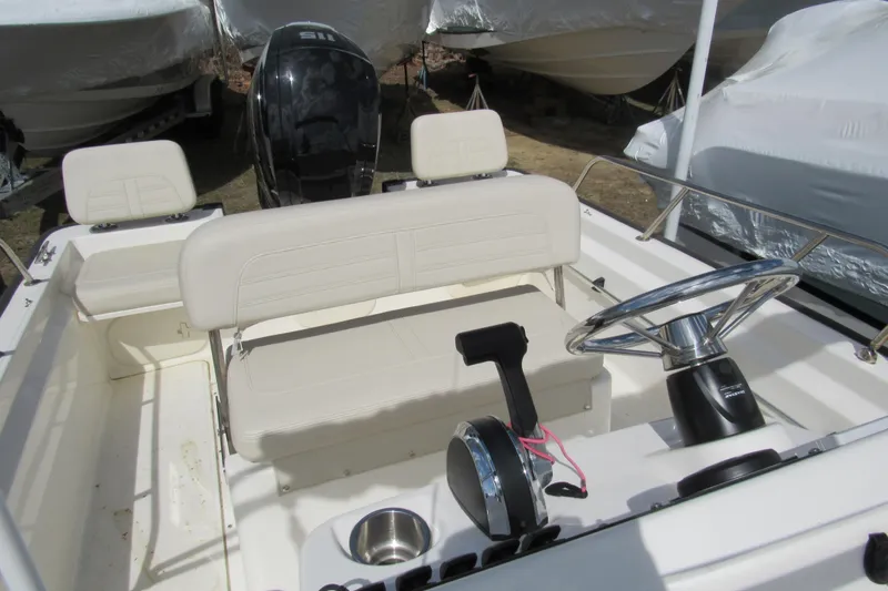 Slide: The Image of 2023 Boston Whaler 170 Montauk boat interior with steering wheel and seating. - 12