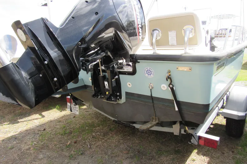 Slide: The Image of 2023 Boston Whaler 170 Montauk boat with outboard motor on trailer, rear view. - 14