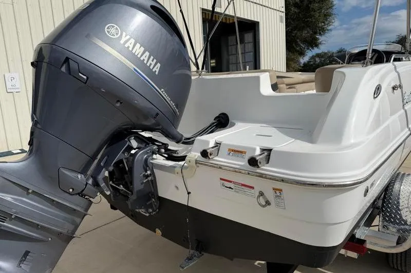Slide: The Image of 2023 Hurricane SunDeck Sport 201 OB boat with Yamaha outboard motor, parked outdoors. - 10