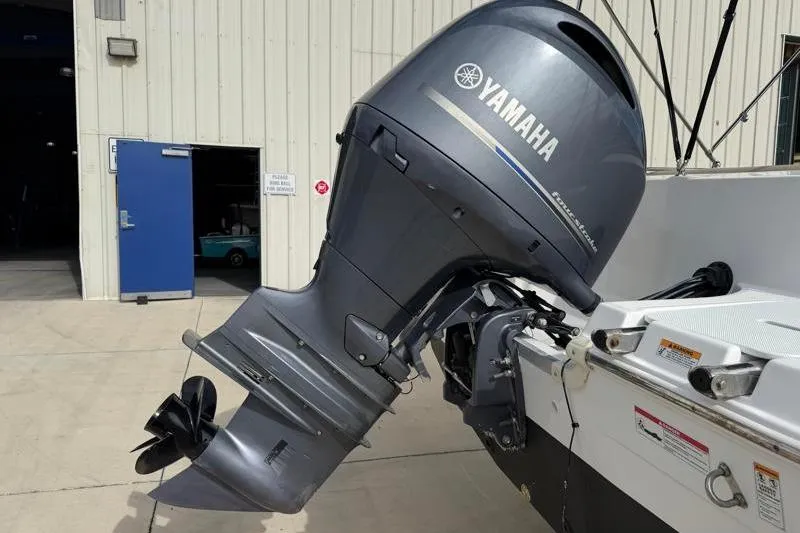 Slide: The Image of 2023 Hurricane SunDeck Sport 201 OB with Yamaha outboard motor in a marina setting. - 11