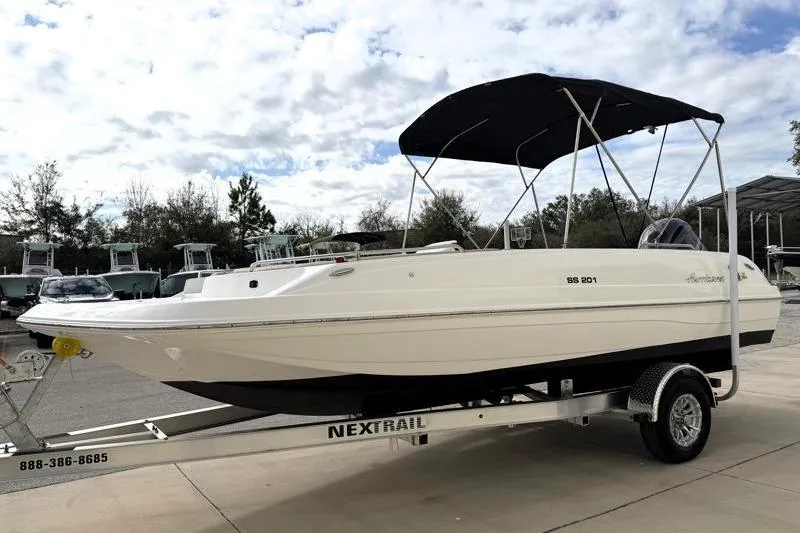 Slide: The Image of 2023 Hurricane SunDeck Sport 201 OB boat on trailer under cloudy sky. - 2
