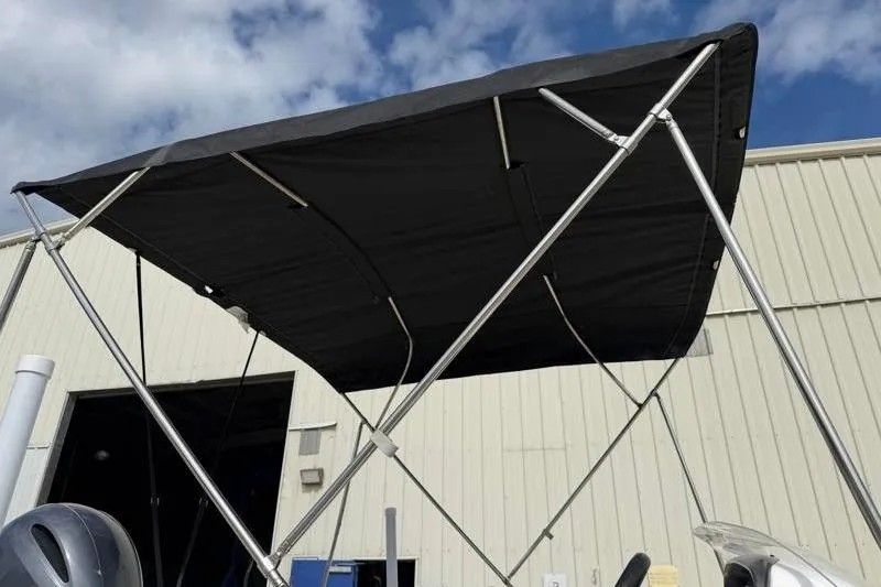 Slide: The Image of 2023 Hurricane SunDeck Sport 201 OB boat canopy against a blue sky. - 28