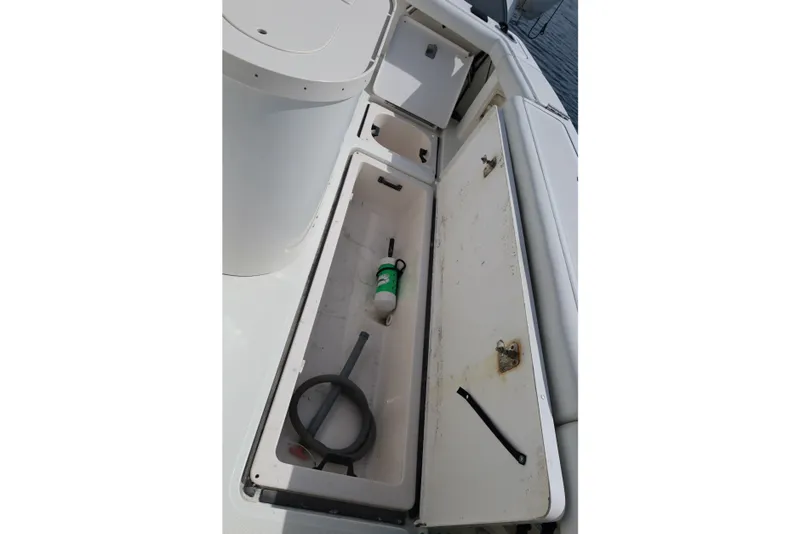 Slide: The Image of Open storage compartment on a 2007 Tiara 4200 Open boat, containing cleaning supplies. - 16