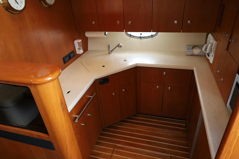 Slide: The Image of Luxurious 2007 Tiara 4200 Open yacht kitchen with wooden cabinetry and modern appliances. - 26