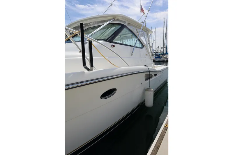 Slide: The Image of 2007 Tiara 4200 Open yacht docked at marina, showcasing sleek white exterior design. - 3