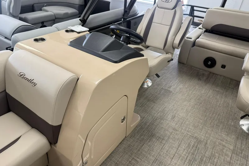Slide: The Image of Interior of 2026 Bentley Pontoons Legacy 243 Swingback with beige seating and steering console. - 8