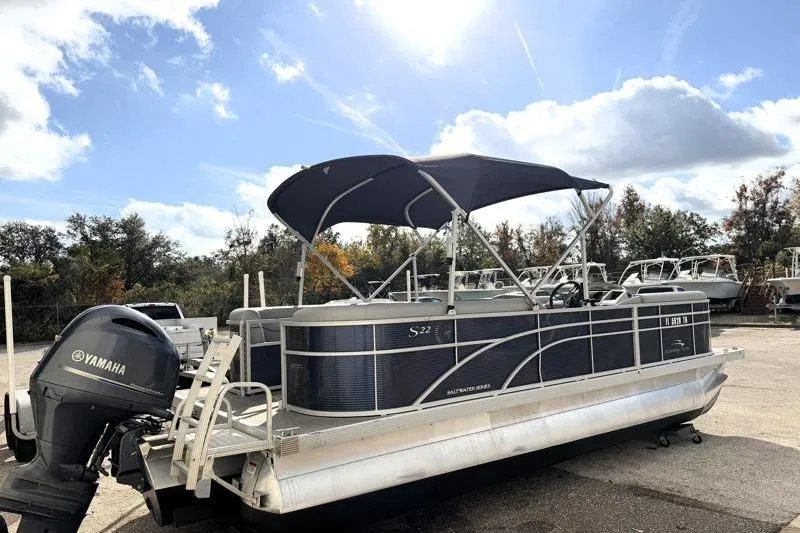 The Image of 2023 Bennington 22SSR pontoon boat with Yamaha motor, parked outdoors under a blue sky. - 0