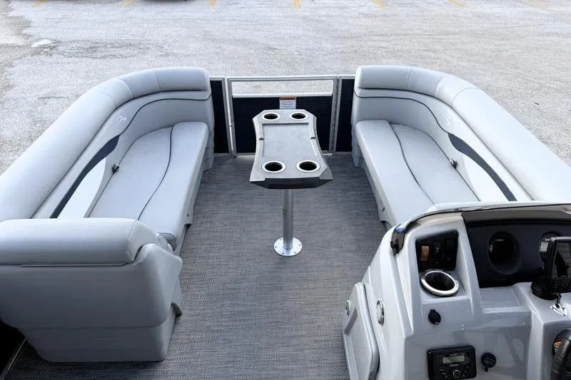 Slide: The Image of 2023 Bennington 22SSR pontoon boat interior with gray seating and central table. - 12