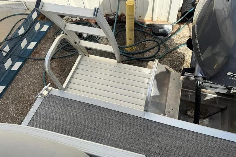 Slide: The Image of 2023 Bennington 22SSR boat with aluminum ladder and motor, docked. - 23