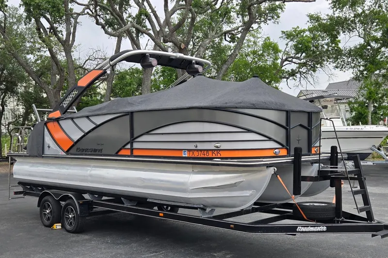 Slide: The Image of 2021 Berkshire 25 Sport CL DC 3.0+ pontoon boat on trailer, covered and parked outdoors. - 23