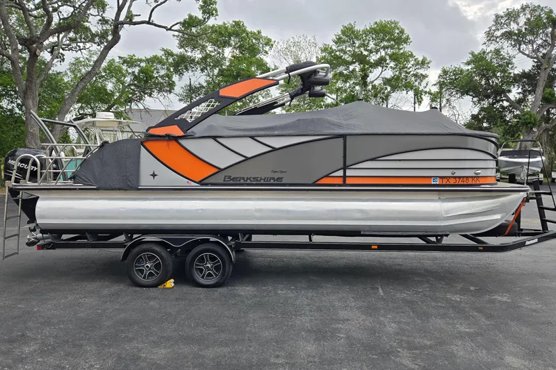 Slide: The Image of 2021 Berkshire 25 Sport CL DC 3.0+ pontoon boat on trailer, covered, parked outdoors. - 24