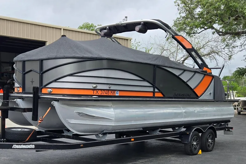 Slide: The Image of 2021 Berkshire 25 Sport CL DC 3.0+ pontoon boat on trailer, covered and parked outdoors. - 29
