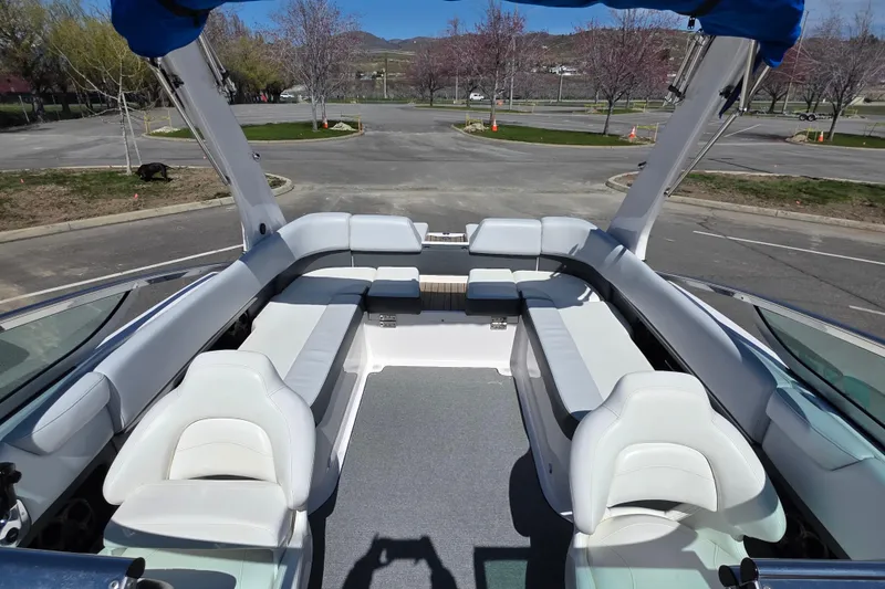 Slide: The Image of 2013 Regal 2500 Bowrider interior with white seating and open layout in a parking area. - 14
